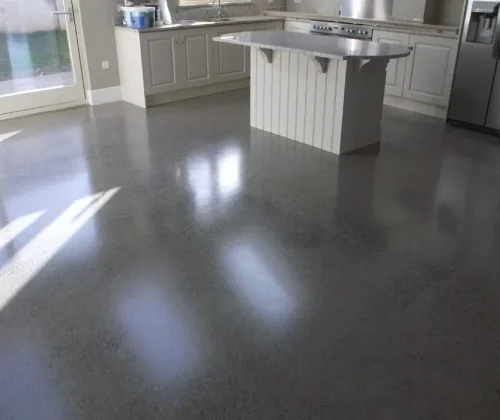 Polished concrete kitchen floor in Albany, NY with white cabinets and stainless steel appliances.